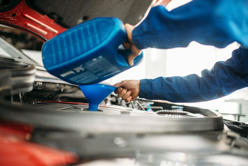 Technician change oil in the car engine